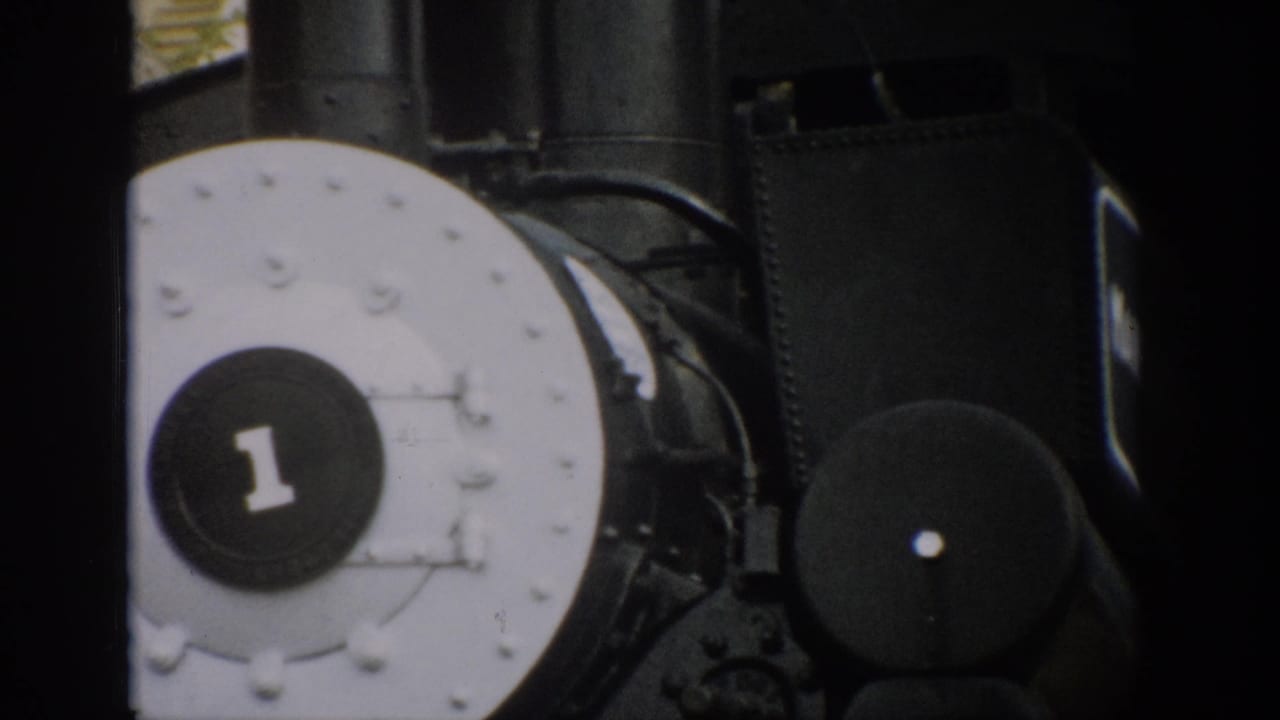 1959 Colorado 8mm frame of a black steam locomotive front, centered on the white plate with a dark number 1 badge.