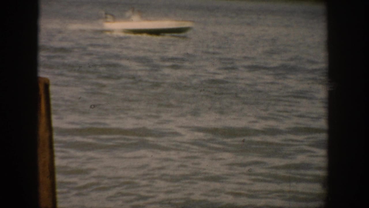 Small motorboat moving across rippled lake water near the top of the frame.