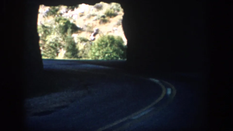 The final frame shows a dark tunnel roadway curving toward a bright opening with sunlit shrubs and hillside outside.