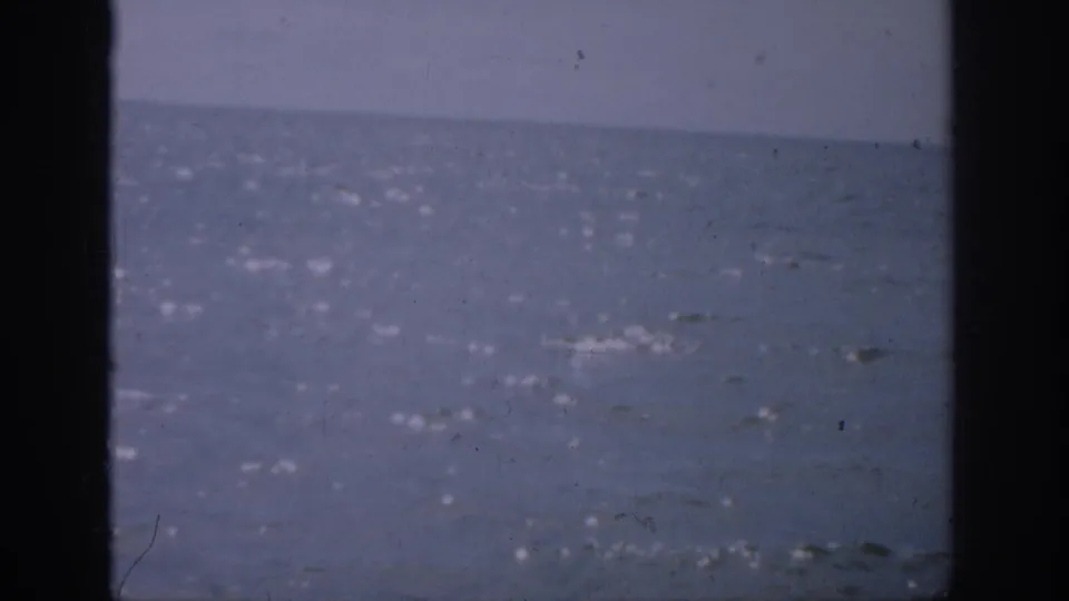 1959 Florida home-movie view of shimmering ocean water, pale sky, soft focus, and dark framing along both sides.
