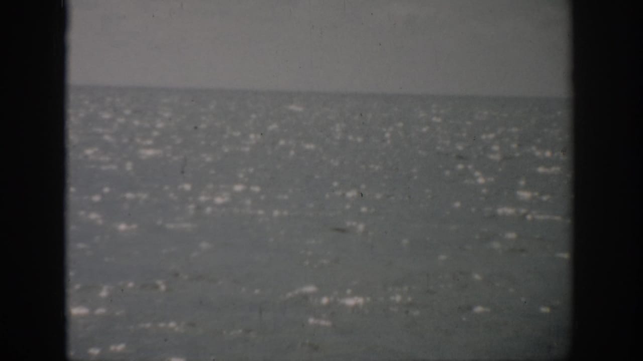 1959 Florida 8mm frame showing a rippling sea and distant horizon under a muted overcast sky.