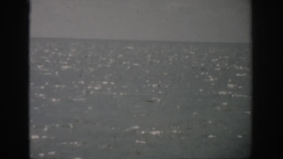 1959 Florida 8mm frame showing a rippling sea and distant horizon under a muted overcast sky.