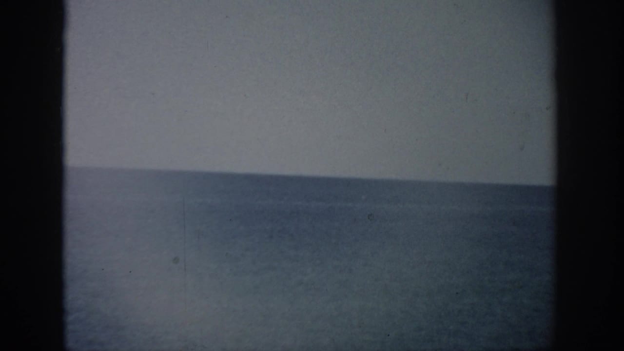 Calm ocean horizon with pale sky and dark 8mm frame edge.