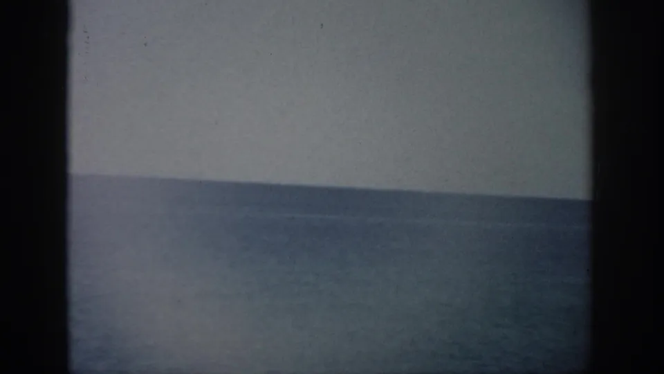 1959 Florida 8mm frame showing mostly ocean and sky with soft focus, speckling, and dark film edges.