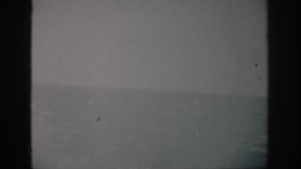 Faded 1959 Florida 8mm ocean frame with a soft horizon, muted sea color, scratches, and dust marks.