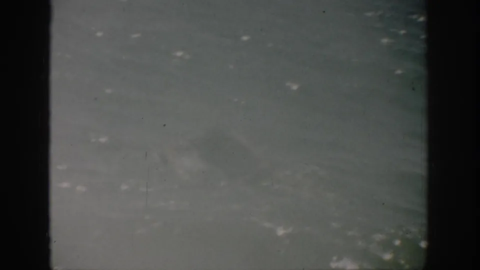 1959 Florida 8mm coastal view showing textured ocean water, faint whitecaps, overcast sky, and worn film borders.
