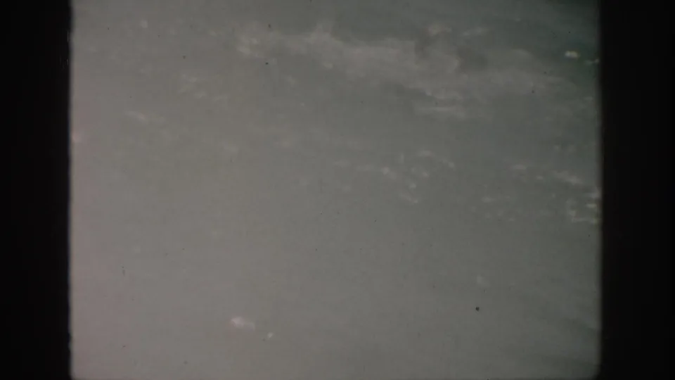 A hazy 1959 Florida sea frame with muted water, indistinct whitecaps, overcast horizon, and visible 8mm wear.