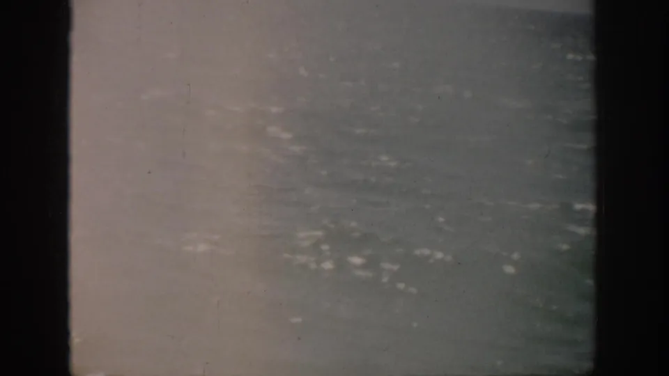 1959 Florida 8mm view of open sea with scattered whitecaps, muted color, and a dark vertical gate edge.