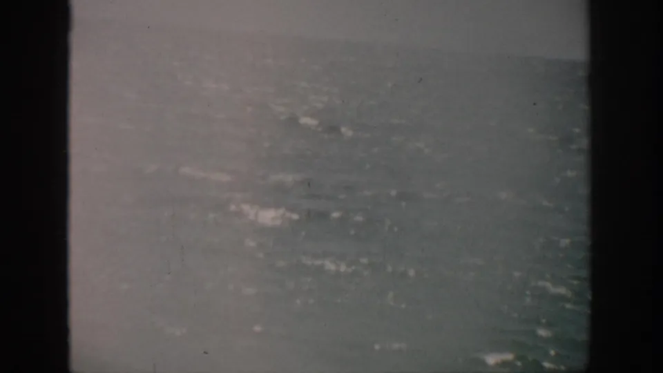 1959 Florida 8mm frame showing muted open ocean, small whitecaps, and overcast haze with visible film grain.