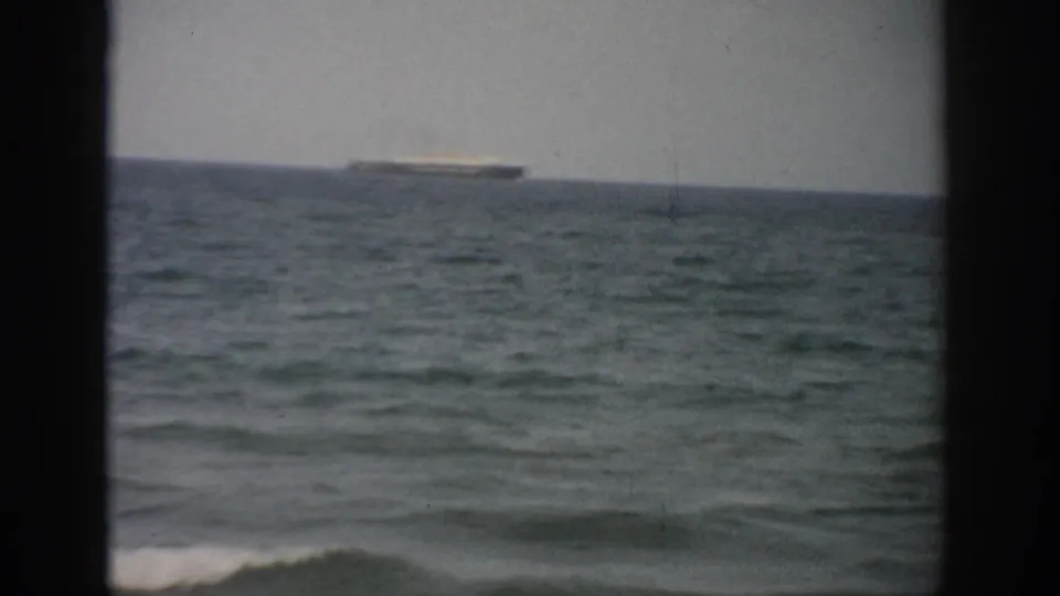 1959 Florida 8mm view of a distant ship crossing the horizon above rolling ocean water.