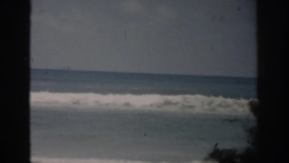 1959 Florida 8mm view of rolling ocean waves and a distant horizon, with film grain and dark side framing visible.