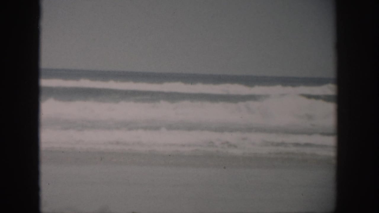 Soft ocean waves under a pale sky with dark 8mm frame borders.