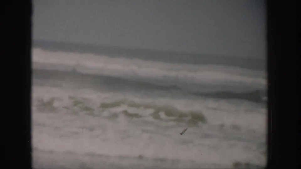 1959 Florida 8mm view of rolling ocean waves, with soft focus, film grain, and a dark gate edge along the side.