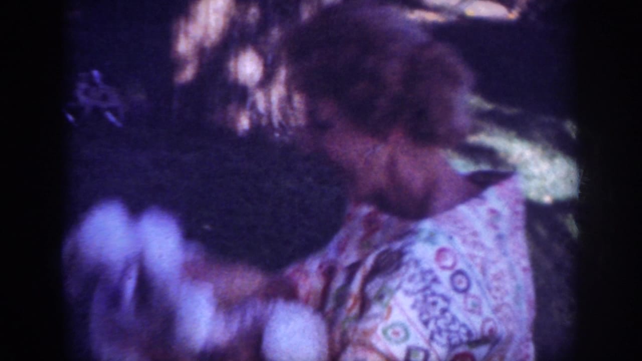 Blainsport, Pennsylvania 1962 home-movie frame with patterned blanket, grass, and soft, blurred backyard movement.