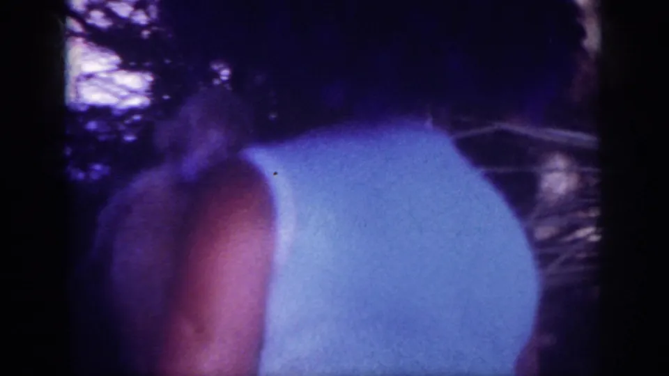 The final frame shows the woman from behind in a white sleeveless dress and large dark hat, with trees and a road or path in the background.