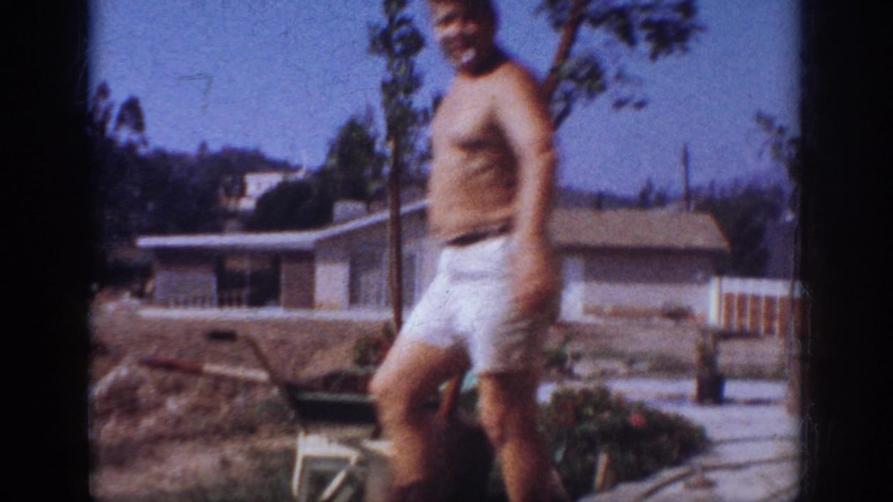 In 1962 Blainsport home-movie footage, a shirtless adult man stands in a suburban backyard during a tree-planting task.