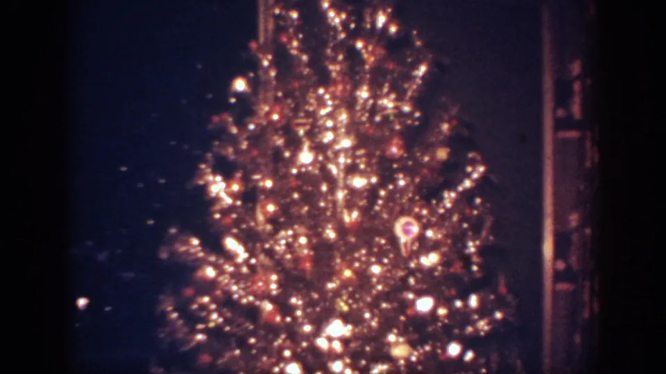 1962 Blainsport frame of the glowing tree turned slightly, with lights blooming against the dark room.