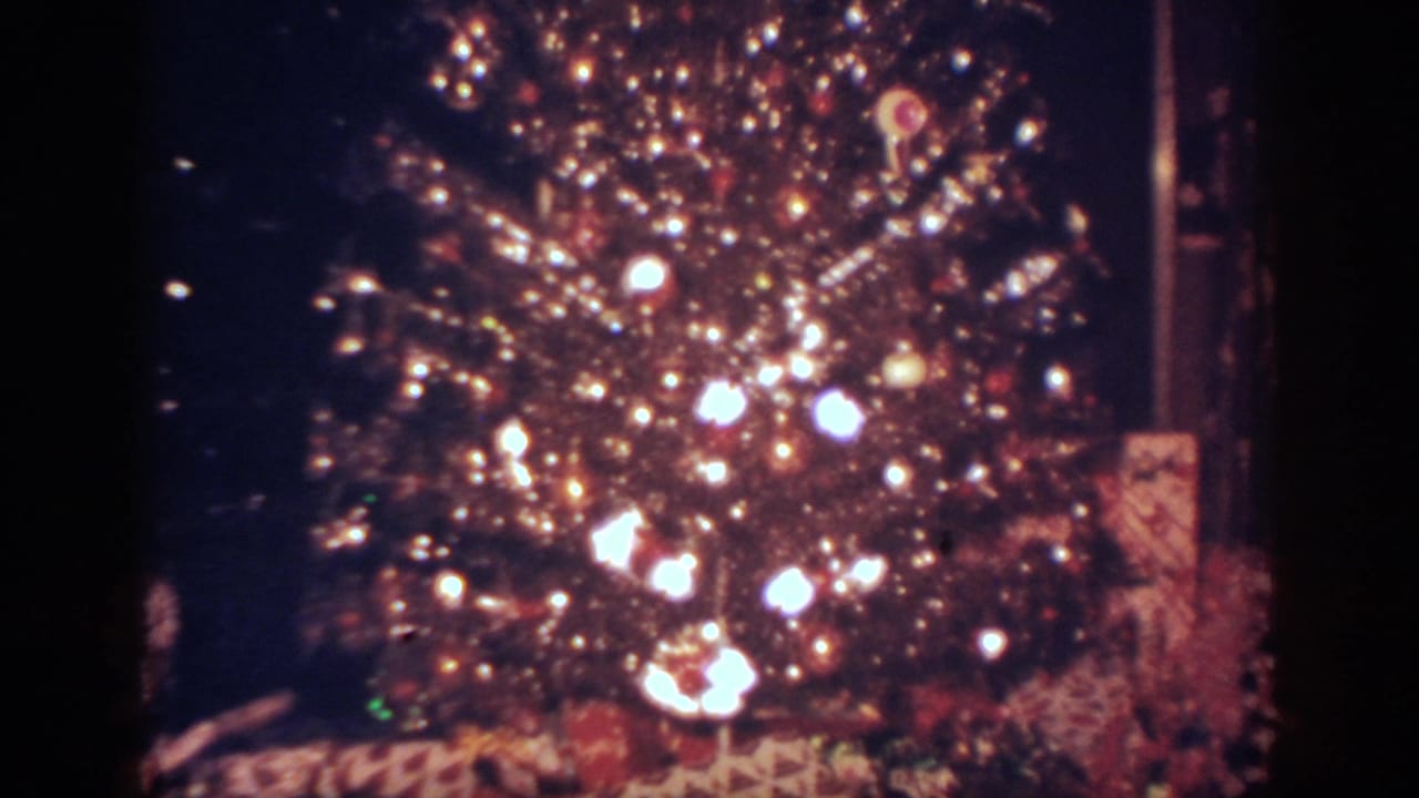1962 Blainsport, Pennsylvania home-movie frame of a glowing Christmas tree with ornaments and gifts below.