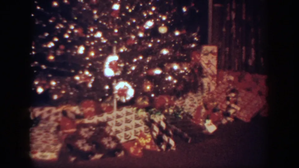 1962 Blainsport, Pennsylvania home-movie frame of the tree base, ornaments, lights, and clustered presents.