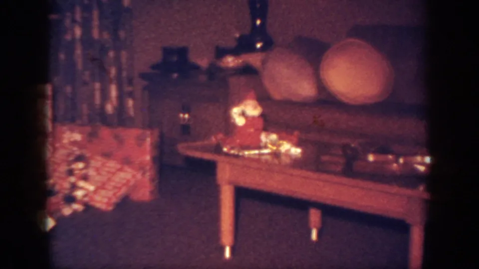 1962 Blainsport living room frame with a Santa decoration, tinsel, coffee table, and sofa cushions.