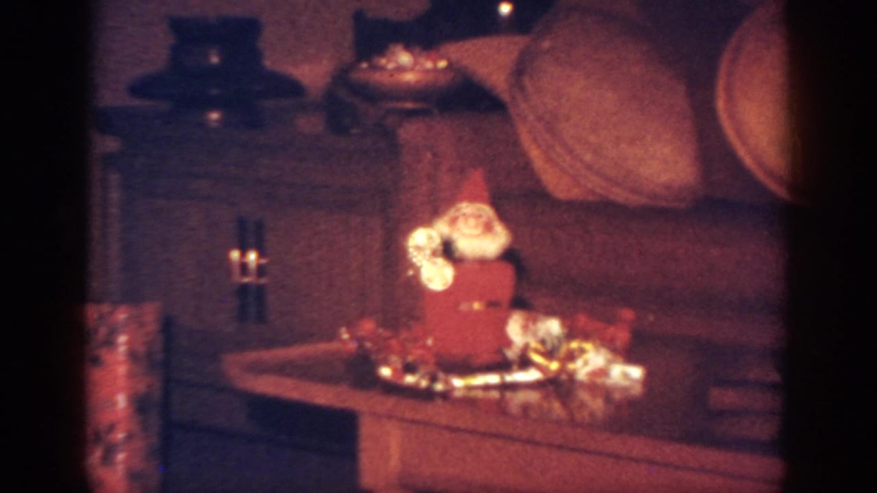 Santa decoration on a table with tinsel and gifts, framed closer than the opening view.