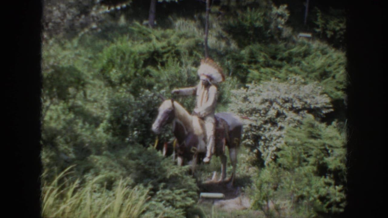 1962 Anaheim frame showing a Native American horseback statue or figure in a landscaped wooded area.