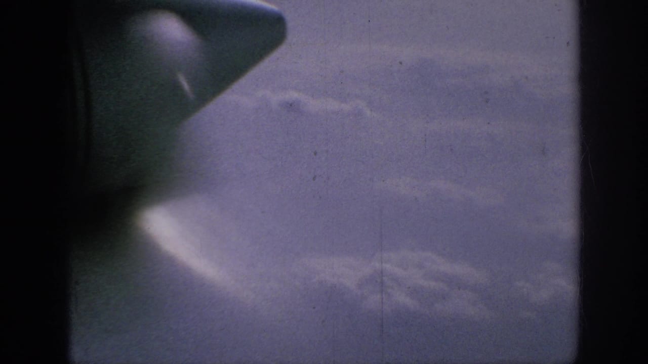 Aircraft wingtip and window divider against a cloudy sky.