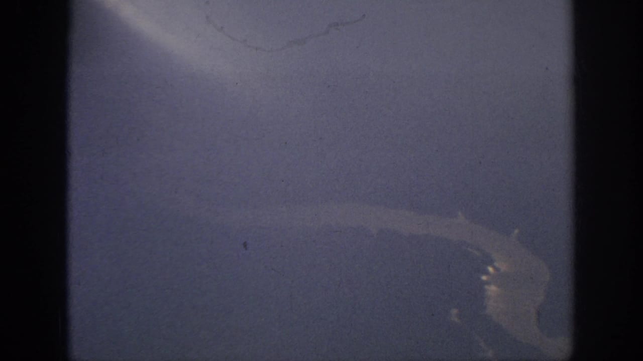 A hazy 8mm aerial view from the Anaheim, California clip, with a pale curved river line near the lower right.