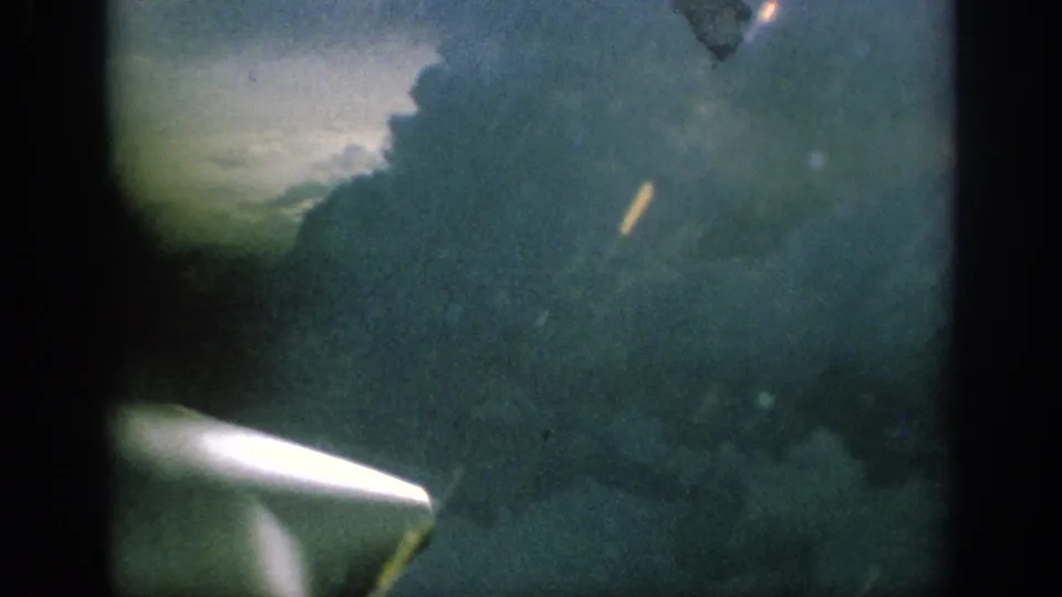 Final 1962 Anaheim frame with a propeller blur at the lower left and clouded sky beyond the window.