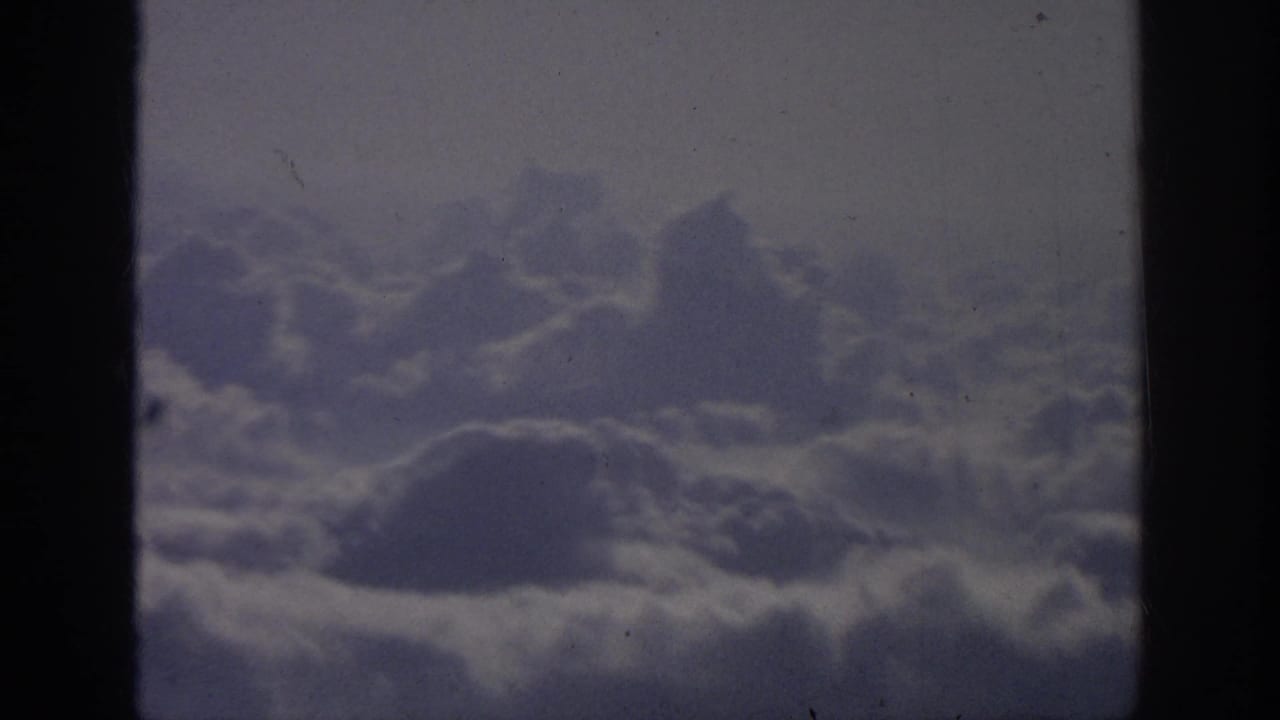Soft cloud layer beneath a hazy sky, bordered by dark frame edges.