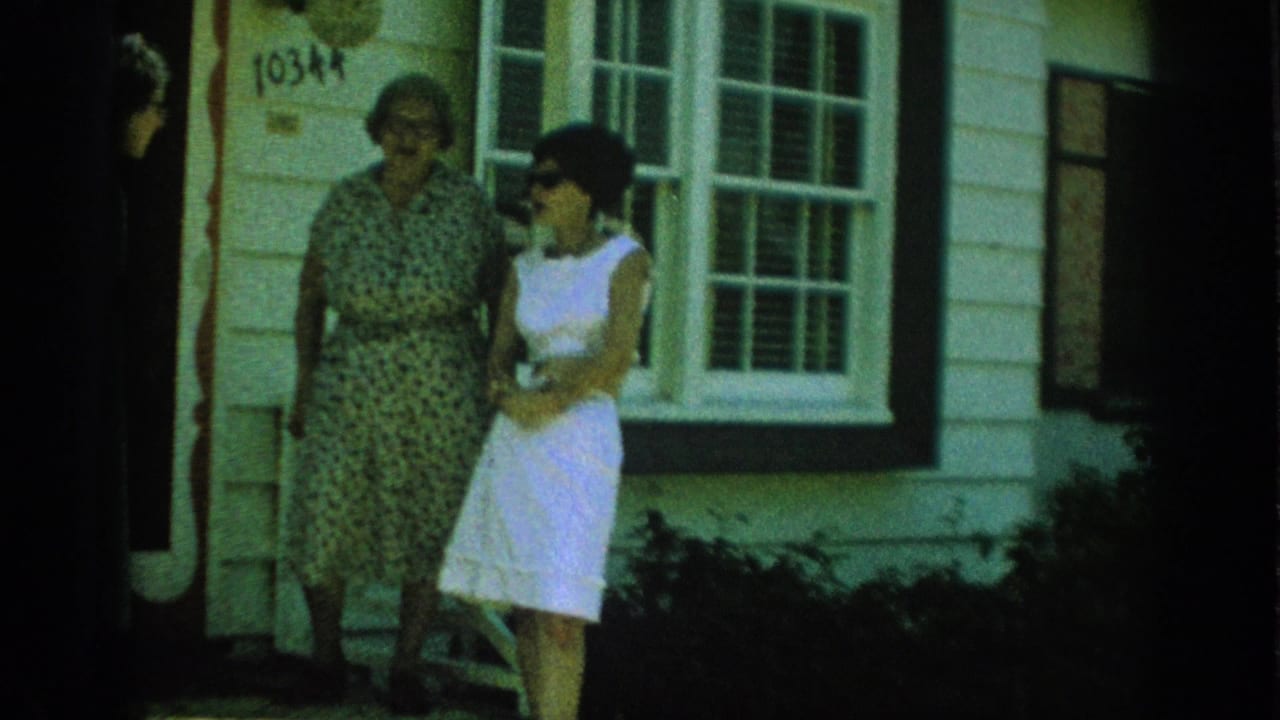 In Anaheim home-movie footage from 1962, an older woman and a younger woman stand near a residential entrance marked 10344.