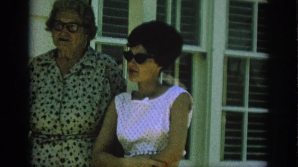 The final frame holds on the two adult women outside the Anaheim residence, both framed tightly against the window and siding.