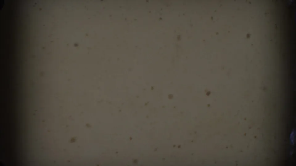 Opening 8mm frame with dark exposure, muted beige surface, black edge areas, and visible film dust before the Raleigh car scene appears.