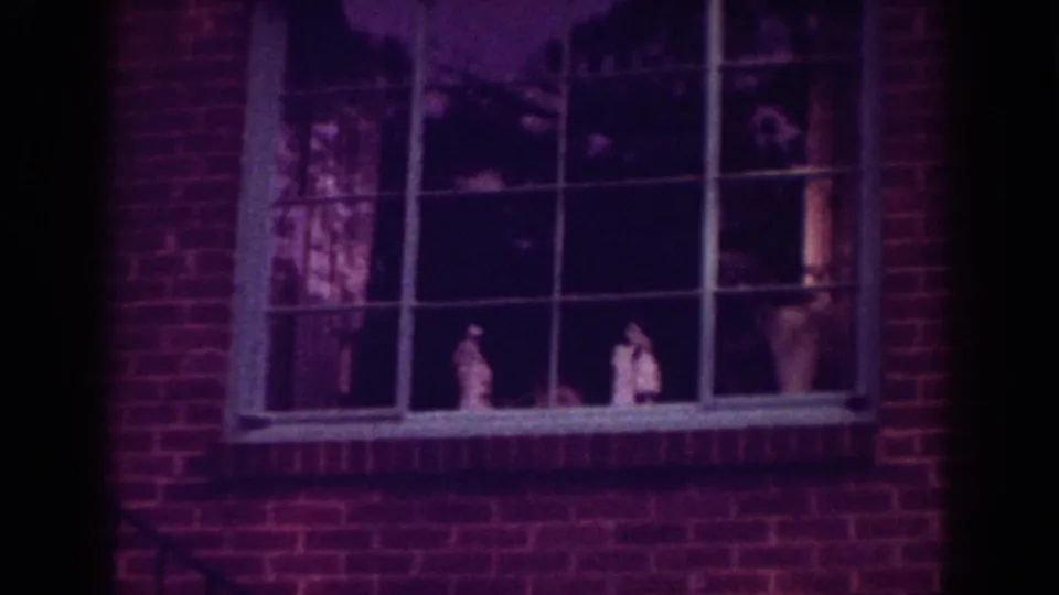 A closer 1962 Raleigh frame shows a divided window set in a brick wall, with small figures or household objects visible behind glass.
