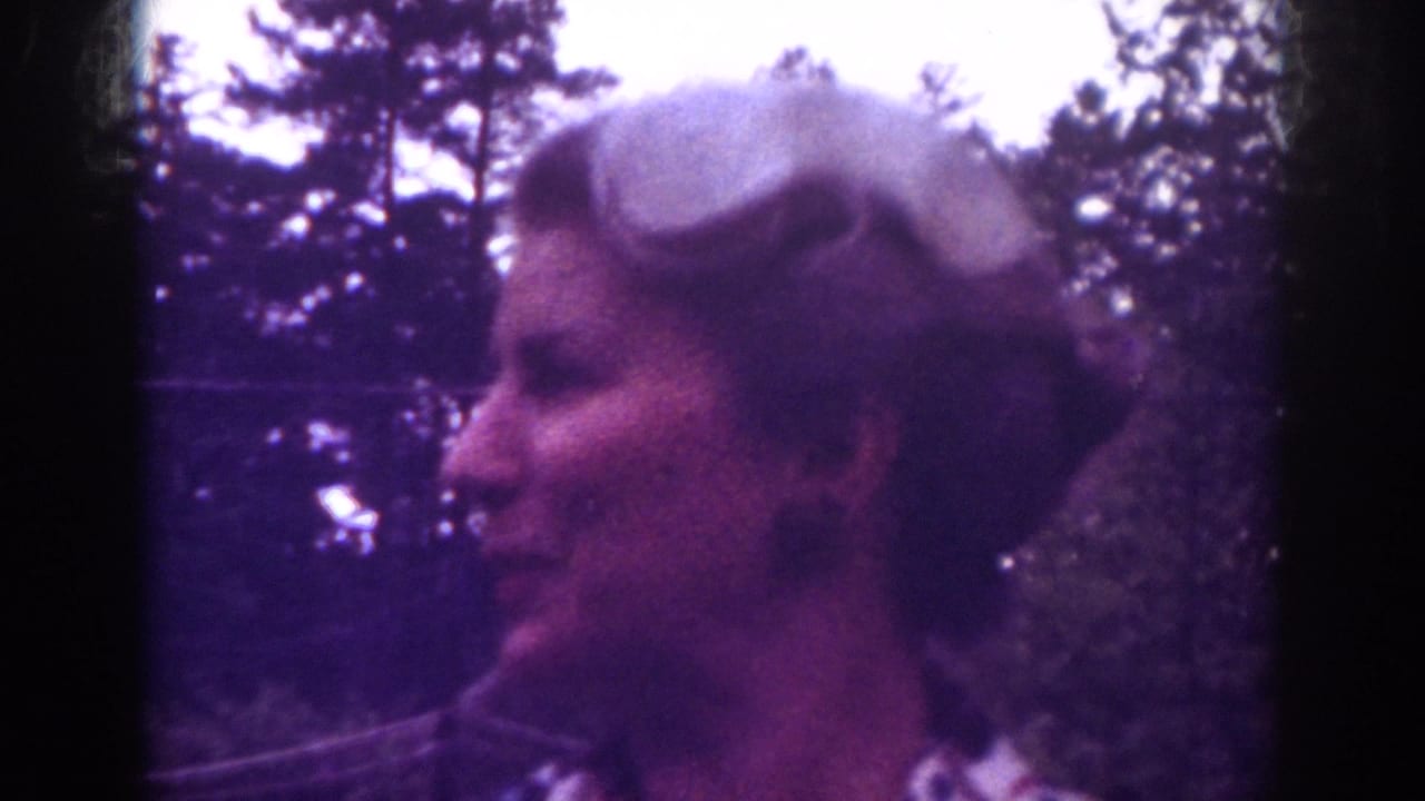 Blonde woman in profile outdoors with trees behind her.