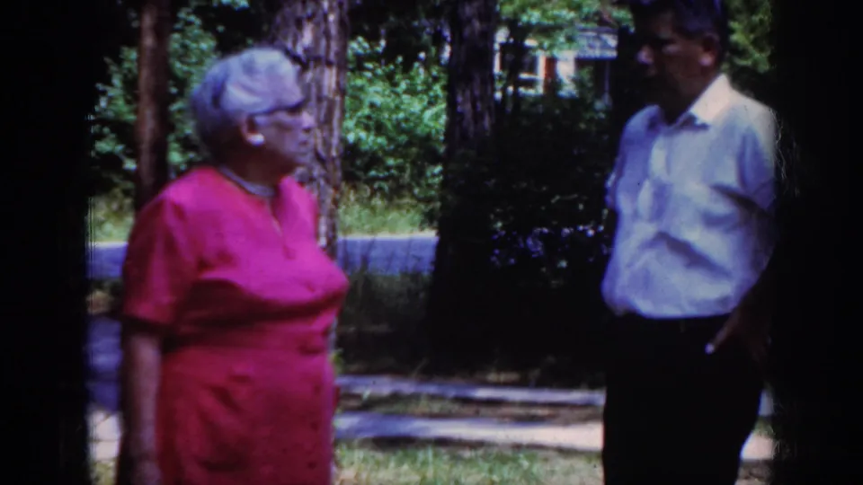 The final frame keeps the Raleigh 1962 outdoor conversation in view, with the woman at left and the man partly near the right edge.