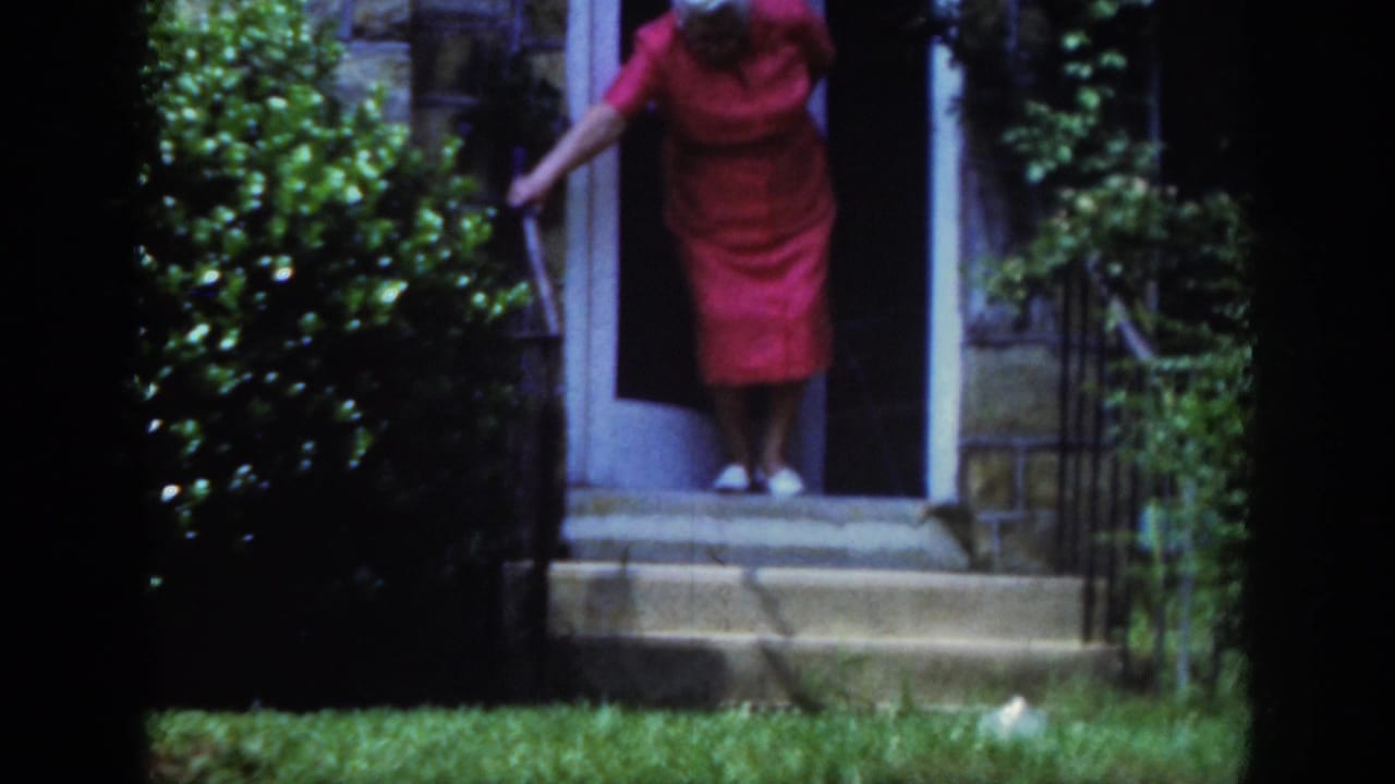 In Raleigh, North Carolina, 1962 home-movie footage, an elderly woman in a red dress begins descending stone steps with a cane.
