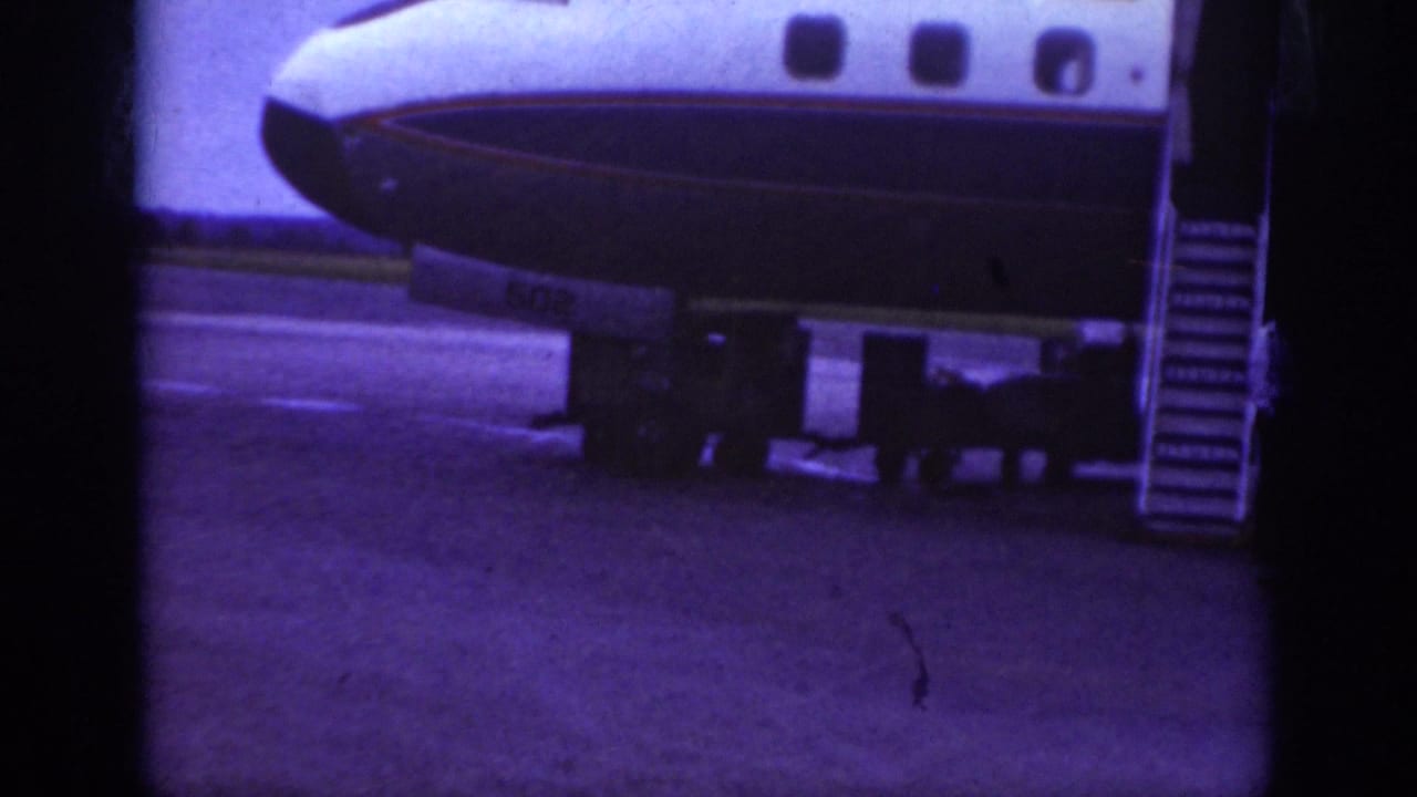 A commercial airliner sits on a Raleigh airport tarmac in 1962, with portable boarding stairs positioned near the doorway.