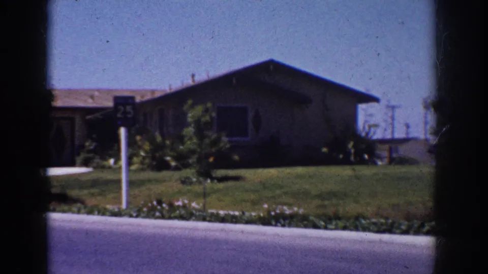 1962 Yorba Linda frame showing a residential lawn, 25 mph sign, single-story house and paved street.