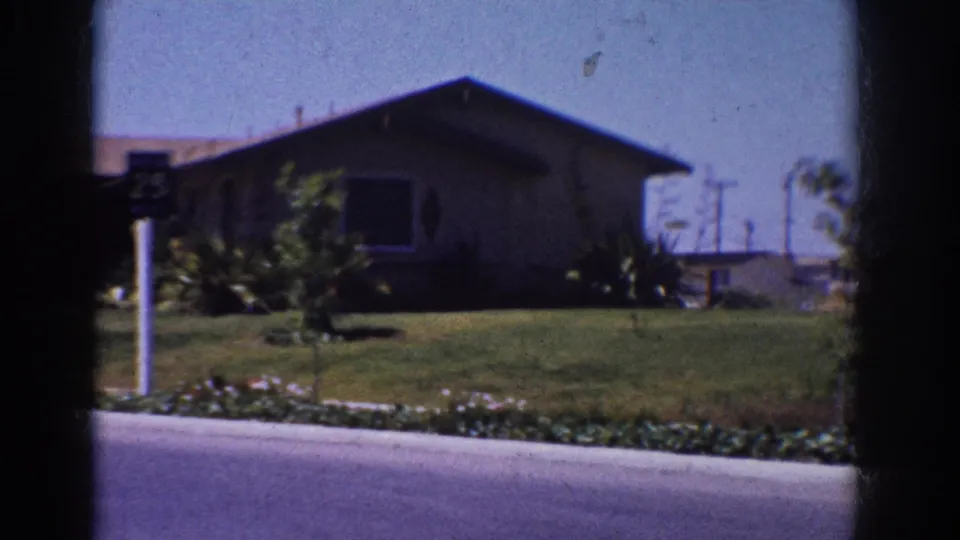 1962 Yorba Linda residential frame with a single-story home, broad lawn, shrubs, street and 25 mph sign.