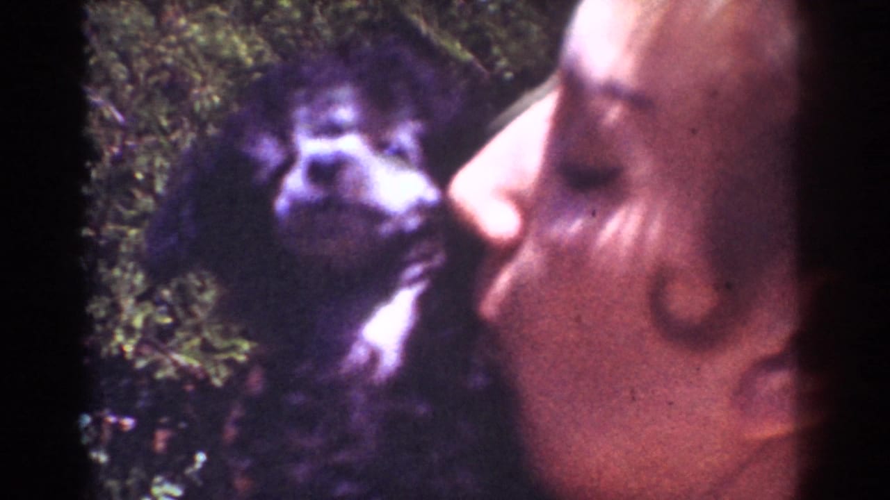 Small black puppy faces a woman leaning in from the right.