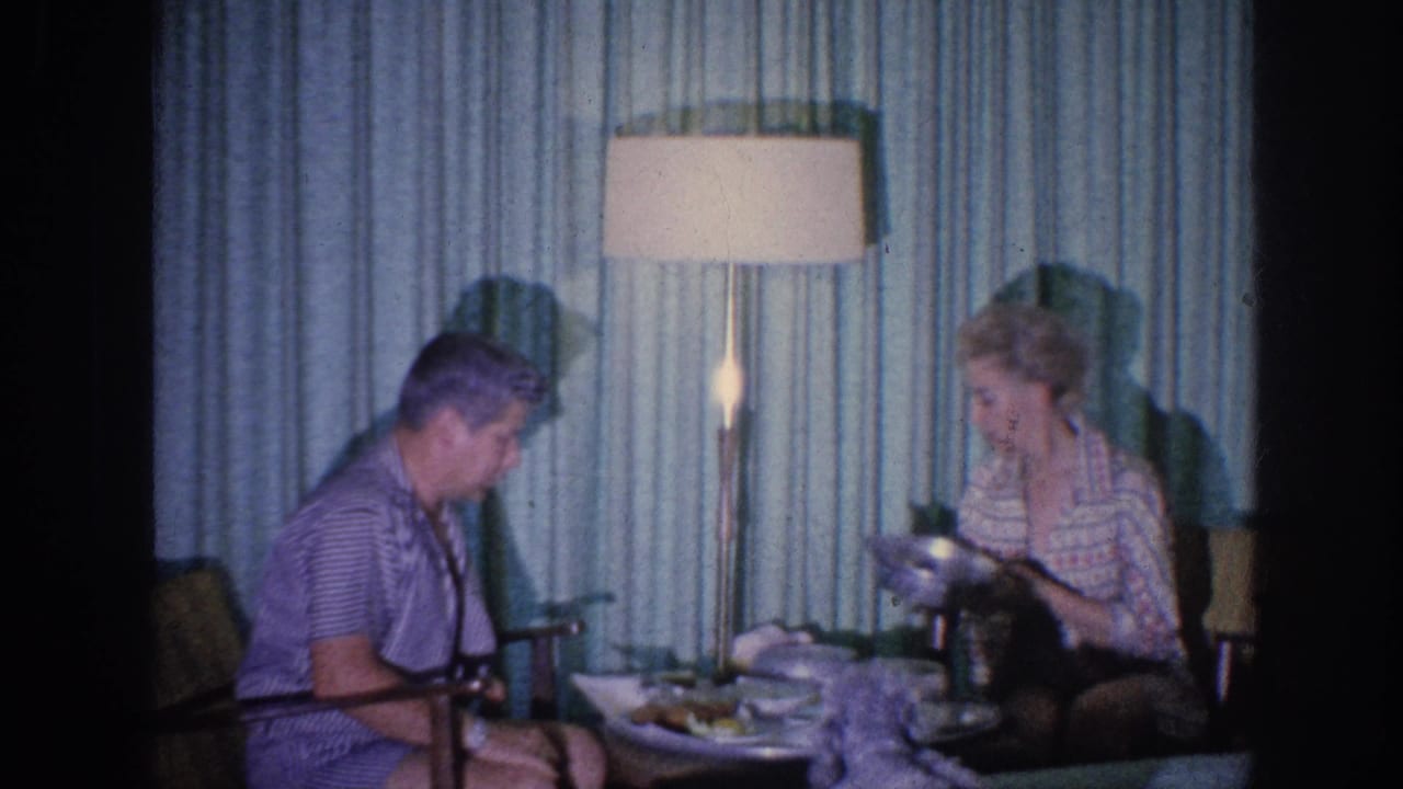1963 Memphis domestic meal scene with an elderly woman serving or adjusting food while an elderly man sits nearby.