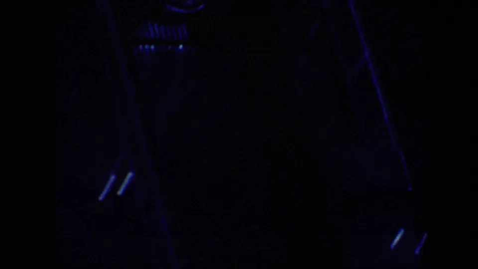 1963 home-movie frame from the Memphis travel clip showing a mostly dark interior edge with faint blue reflections and film grain.