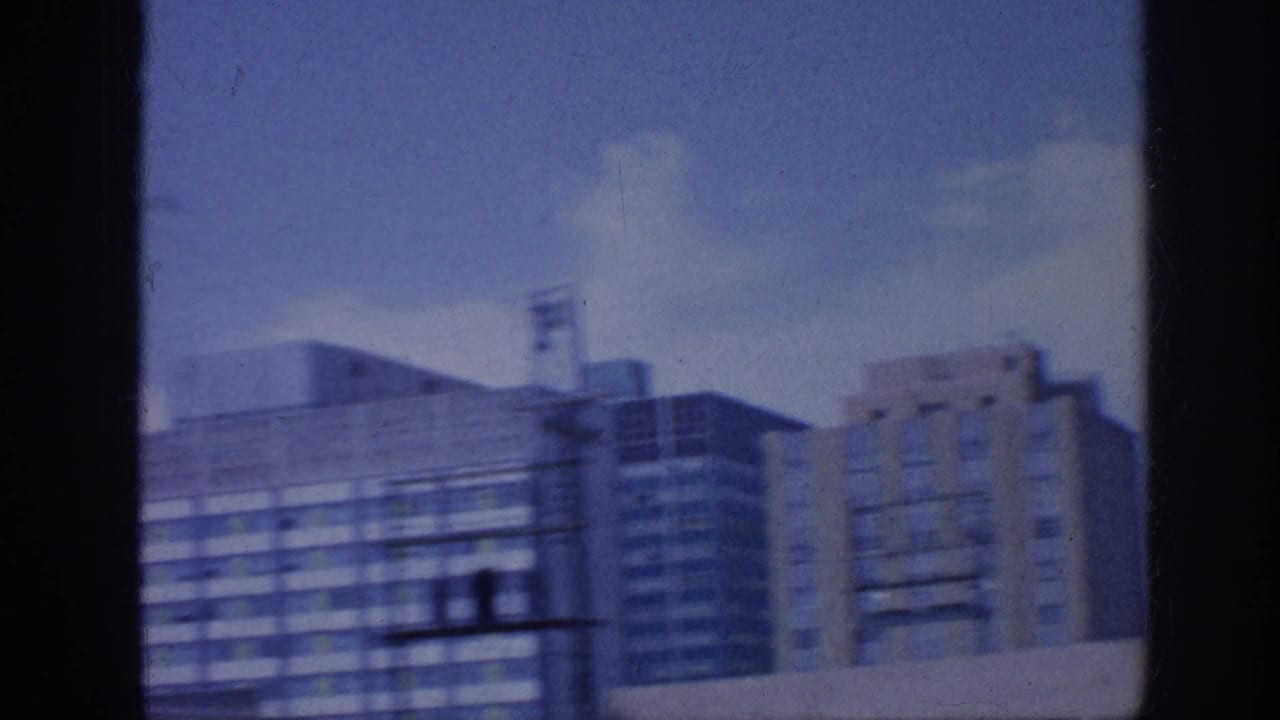 Downtown buildings seen through a window with blue sky and soft focus.