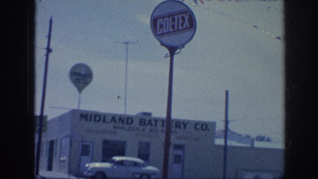 Midland Battery Co. storefront with a Coltex sign and a parked car outside.