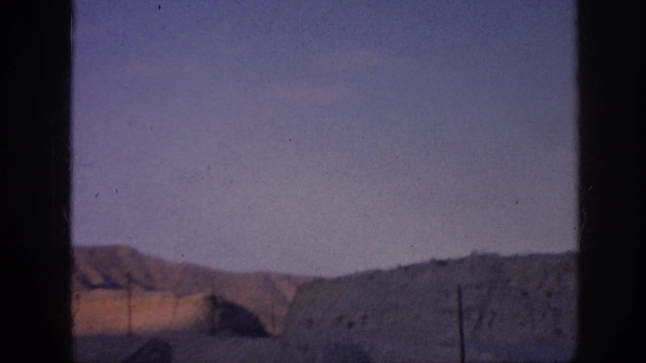 Distant earth-toned hills beneath a purple-blue sky with dark frame borders.