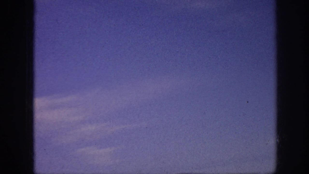 Blue sky with faint clouds between dark vertical frame edges.