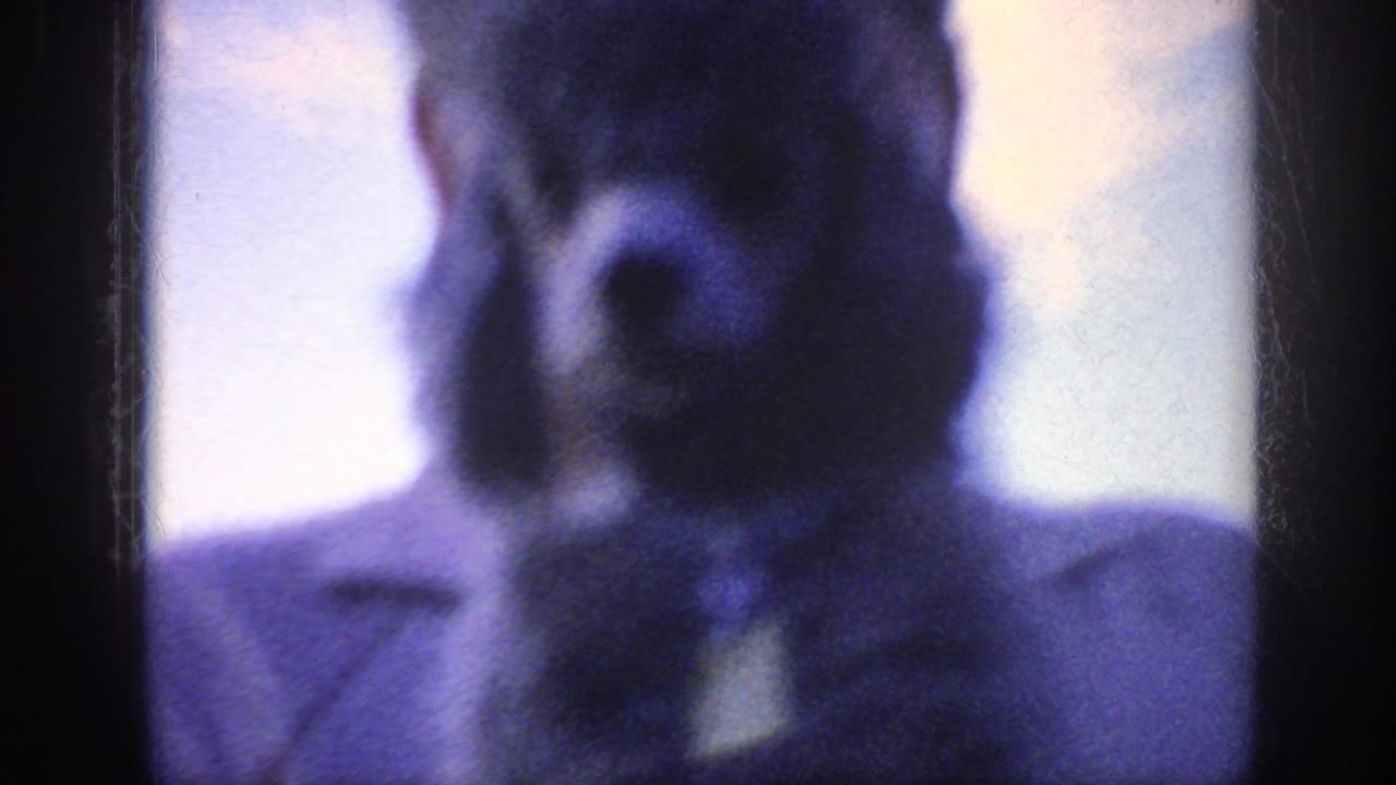 Very soft 1963 home-movie frame from the Memphis reel showing a close adult face, largely out of focus and tinted blue.