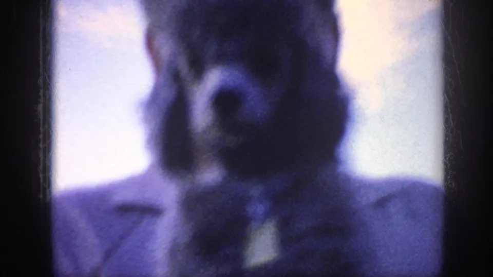 Very soft 1963 home-movie frame from the Memphis reel showing a close adult face, largely out of focus and tinted blue.