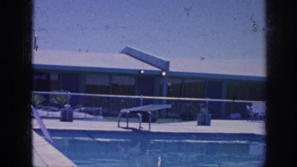 The Memphis 1963 footage shows a large outdoor pool, diving board, chain-link fence, and low motel-style building under bright sun.